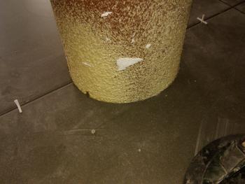 Tegel uitgeslepen met de klokboor zodat hij mooi past rond de steunpaal in de leefruimte